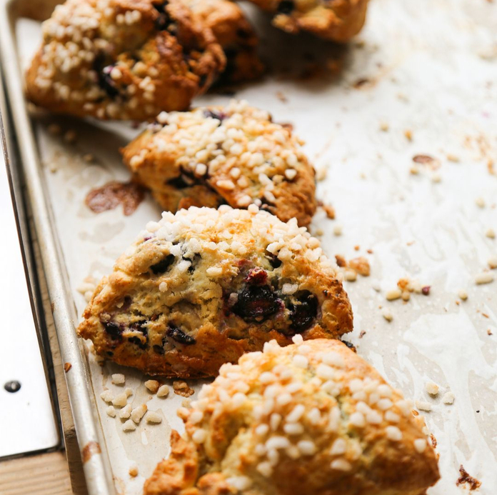 Baked blueberry scones with seeds on a parchment-lined baking sheet.